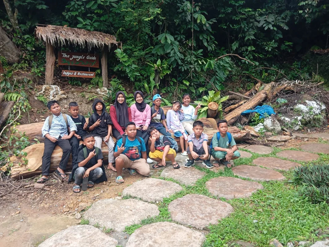 Tourists talking with local Indonesian students in Bukit Lawang classroom